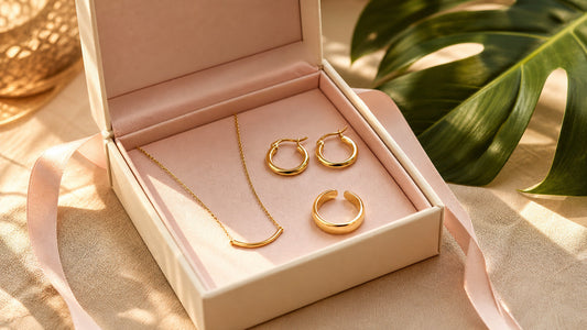 Offene Schmuckbox mit goldfarbenen Creolen, Kette und verstellbarem Ring