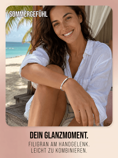 Silberfarbener THIORA Armreif in einer sonnigen Strandszene