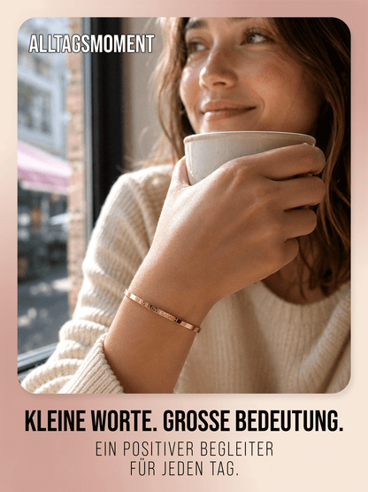 Goldfarbener Live Love Laugh Armreif von THIORA in einer warmen Cafészene